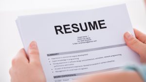 A woman holding her resume in her hands.